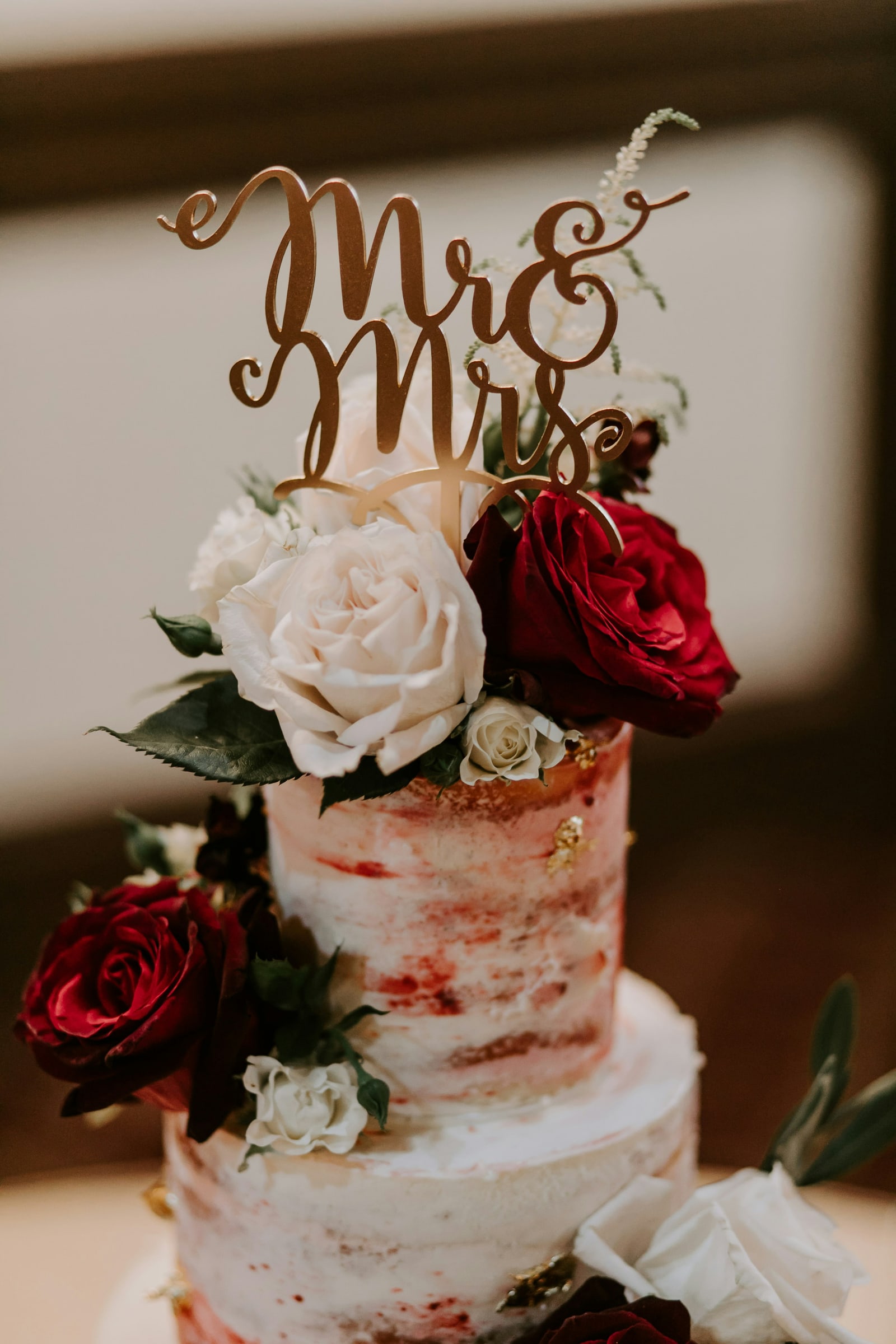 Een bruidstaart met rozen en een Mr & Mrs topper.